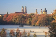 Panoramic view of the Englischer Garten with the skyline of the Frauenkirche and the Theatinerkirche in the background in Munich in autumn.
