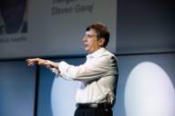 A man stands on a stage at Graphene Week Munich.