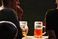 Two beer steins on a table in a beergarden in Munich at sunset.