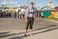 A man at the Oktoberfest who is wearing a traditional bavarian costume.