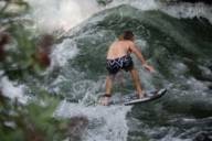 A surfer is surfing a wave on the Eisbach.