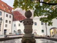 A dove sits on the fountain in the Alter Hof in Munich.