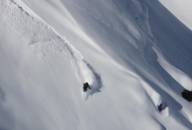 A skier during the descent in deep snow.