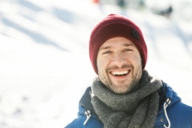 A man is wearing a red knitted hat on a winter day in Munich.