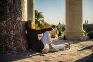 A woman leans against a column of the Monopteros building in the English Garden in Munich