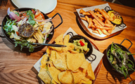 Richly laid table with various dishes arranged on small trays and in pans.