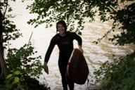 Surfer with board in hand gets out of the water.