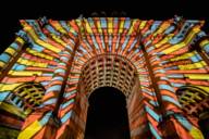 The Siegestor in Munich at night, illuminated with colourful lights