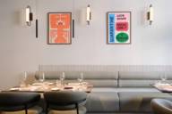 Arredi moderni e illustrazioni colorate caratterizzano l'interior design del ristorante stellato Brothers di Schwabing.