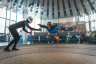 A young lady flies with an employee in the wind tunnel of the Jochen Schweizer Arena in Munich.