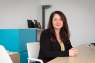 Portrait of a woman with long brown hair in an office in Munich.