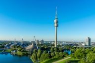 Panoramic view from the Olympiaberg with Olympic Lake, Olympic Tower and the headquarter of BMW in Munich in the background.