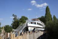 A disused excursion boat is accessible via a metal staircase.