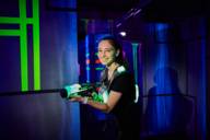 A woman stands with laser tag equipment in the LaserZone Arena in Munich.