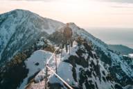 A man is standing on top of Herzogstand in the surrounding region of Munich.