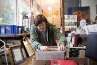 A man is having a look at a box full of records in an antique shop in Munich.