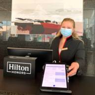 A receptionist stands with a tablet at the Hilton Munich Airport hotel.