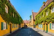 View of the yellow settlement houses and fountains of the Fuggerei.