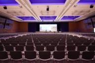 Empty rows of chairs in the foreground with a view of the podium