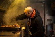 A man is grilling meat in food truck in Munich.