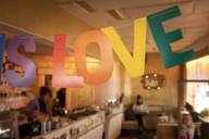 A colourful garland with the words LOVE hangs in a café.