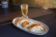 Krautrahmstrudel on a plate next to a glass of wine