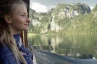 A young woman watching the Königssee from the ship