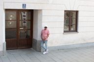 Ein Mann mit Sonnenbrille lehnt an einer Hauswand in München.