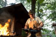 Composer Harold Faltermayer forming iron in front of a hut