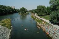 People bathing in the Isar river in Munich in the sunshine.