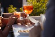 Una donna in piedi con un drink in un bar su una terrazza sul tetto a Monaco di Baviera.