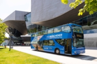 Un bus touristique bleu à deux étages devant le BMW Welt à Munich.