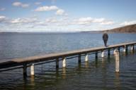 A person stands on a jetty at the Ammersee near Munich