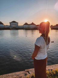 Influencer Nina Zasche in front of Nymphenburg Palace during sunset.