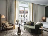 A bedroom at Rosewood in Munich with a view from the window of a house facade