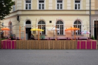 A colourful pub garden with a raffia and bamboo railing in Munich.