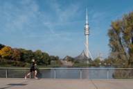 A runner in front of the background of the Olympic Tower in the Olympic Park Munich