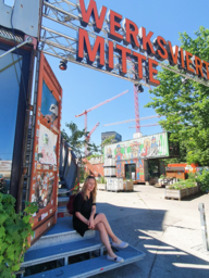 Sarah Althaus sits at the entrance to Werkviertel-Mitte in Munich.