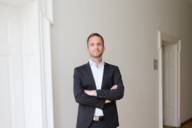 Prof. Dr. Christoph Spinner, specialist for internal medicine and infectiology, stands in front of a white wall.