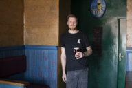 The founder of Tilmans Brewery, Tilman Ludwig, stands in a pub with a glass of beer