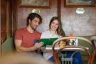 A young man and a young woman are sitting at a table in the Valentin-Karlstadt-Musäum in Munich.