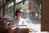 Young woman sitting at a window in a tram in Munich.