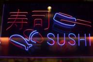 Blue and red neon sign with the lettering Sushi and Asian characters