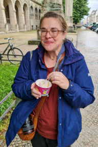 Nicole Nobs is eating an ice cream in the state capital Munich and carrying a camera.