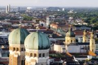 View over the roofs of Munich with the towers of the Frauenkirche in the front.