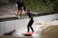 The professional holds the surfer's hand at the beginning.