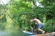 A boy jumps from a small bridge into the Ländkanal in Munich.