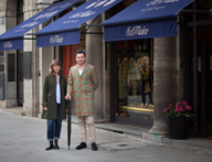 A woman and a man in a coat in front of the shop of Eduard Meier in Munich