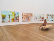 Influencer Sarah Althaus sits in front of paintings at the Pinakothek der Moderne in Munich.