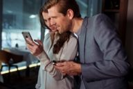 A woman is showing a man something in her mobile phone in the restaurant Esszimmer at BMW Welt in Munich. 